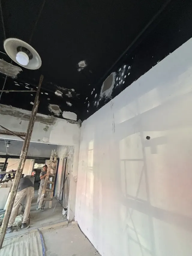 Local en obra con el cielorraso en reparación y sus luminarias
